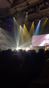 A vibrant TV screen showing a live Ghanaian music concert with excited viewers.