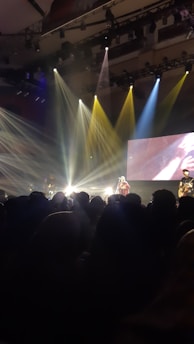 A dynamic live concert scene featuring a rock band performing on stage with vibrant lights and an enthusiastic crowd.