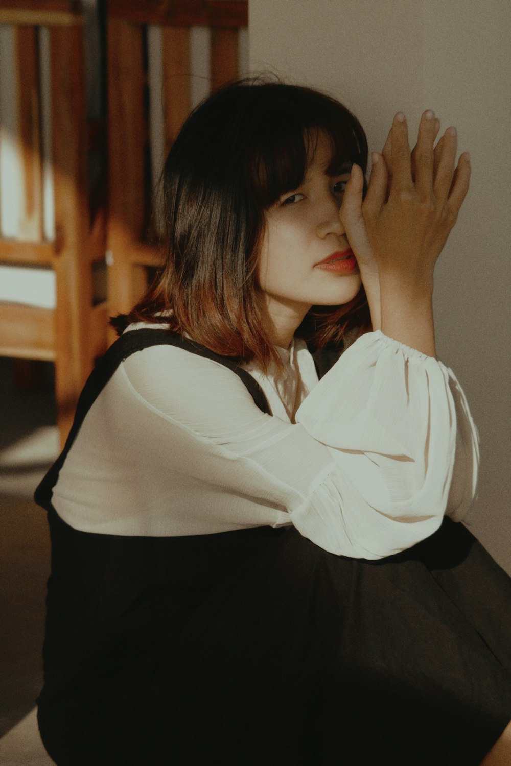 woman in white long sleeve shirt covering her face