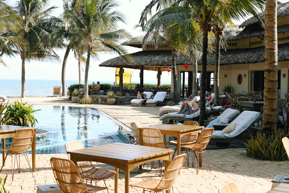 brown wooden table and chairs near swimming pool during daytime