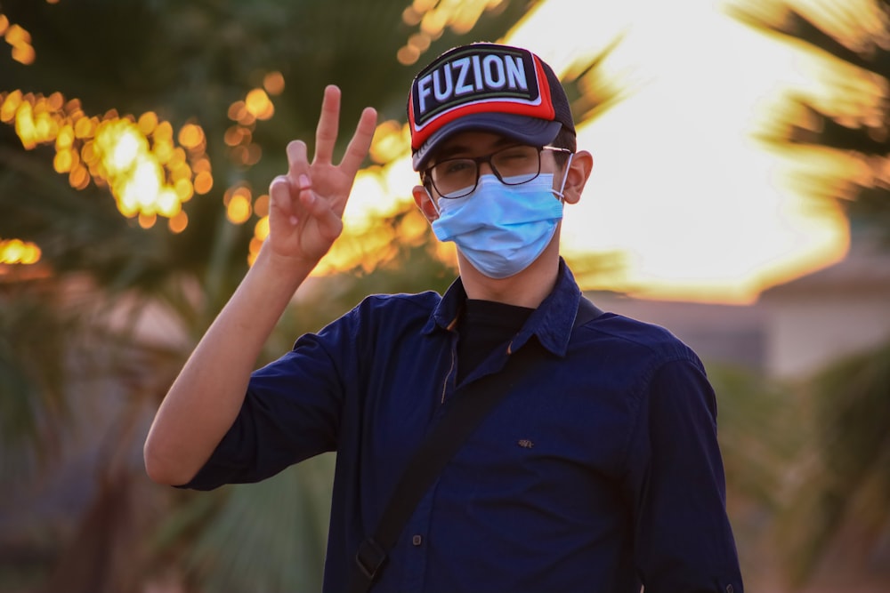 man in blue button up shirt wearing black and white fitted cap