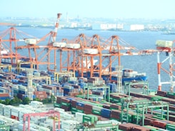 A busy port with cargo containers and cranes in operation.