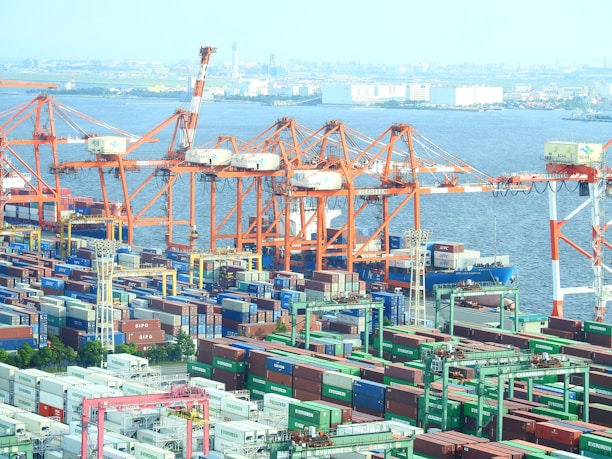 A busy shipping port with containers stacked and cranes in operation, symbolizing logistics and shipping activities.