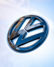 silver mercedes benz emblem on white surface