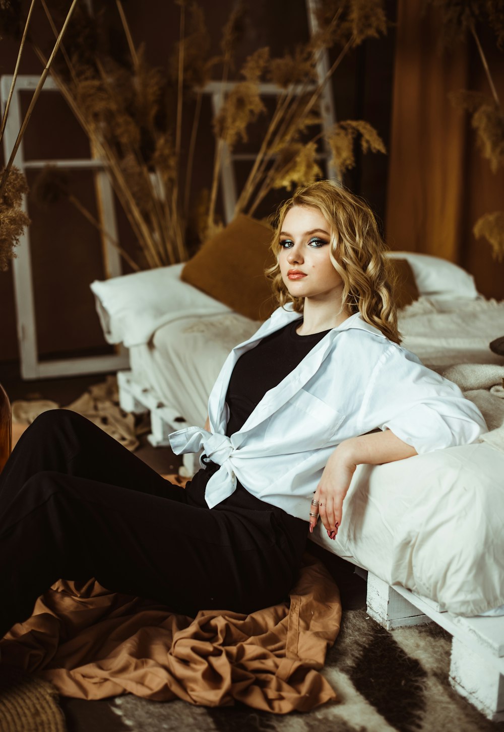 femme en chemise blanche assise sur un canapé blanc