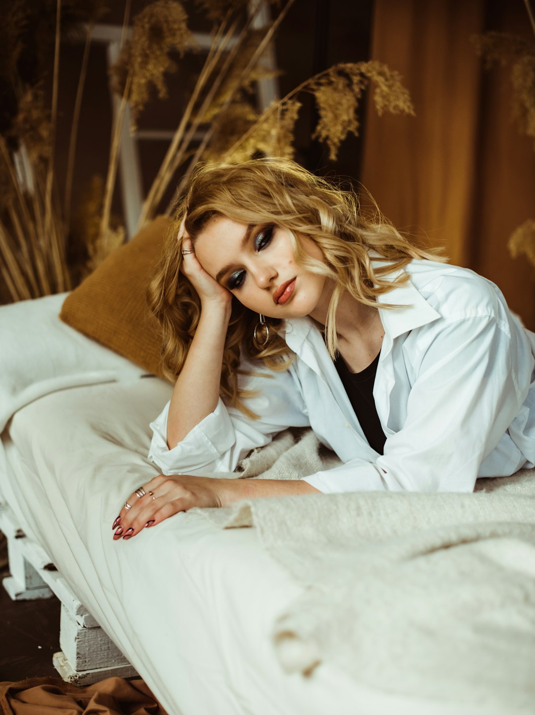 woman in white button up shirt lying on bed