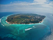 green and brown island under blue sky during daytime