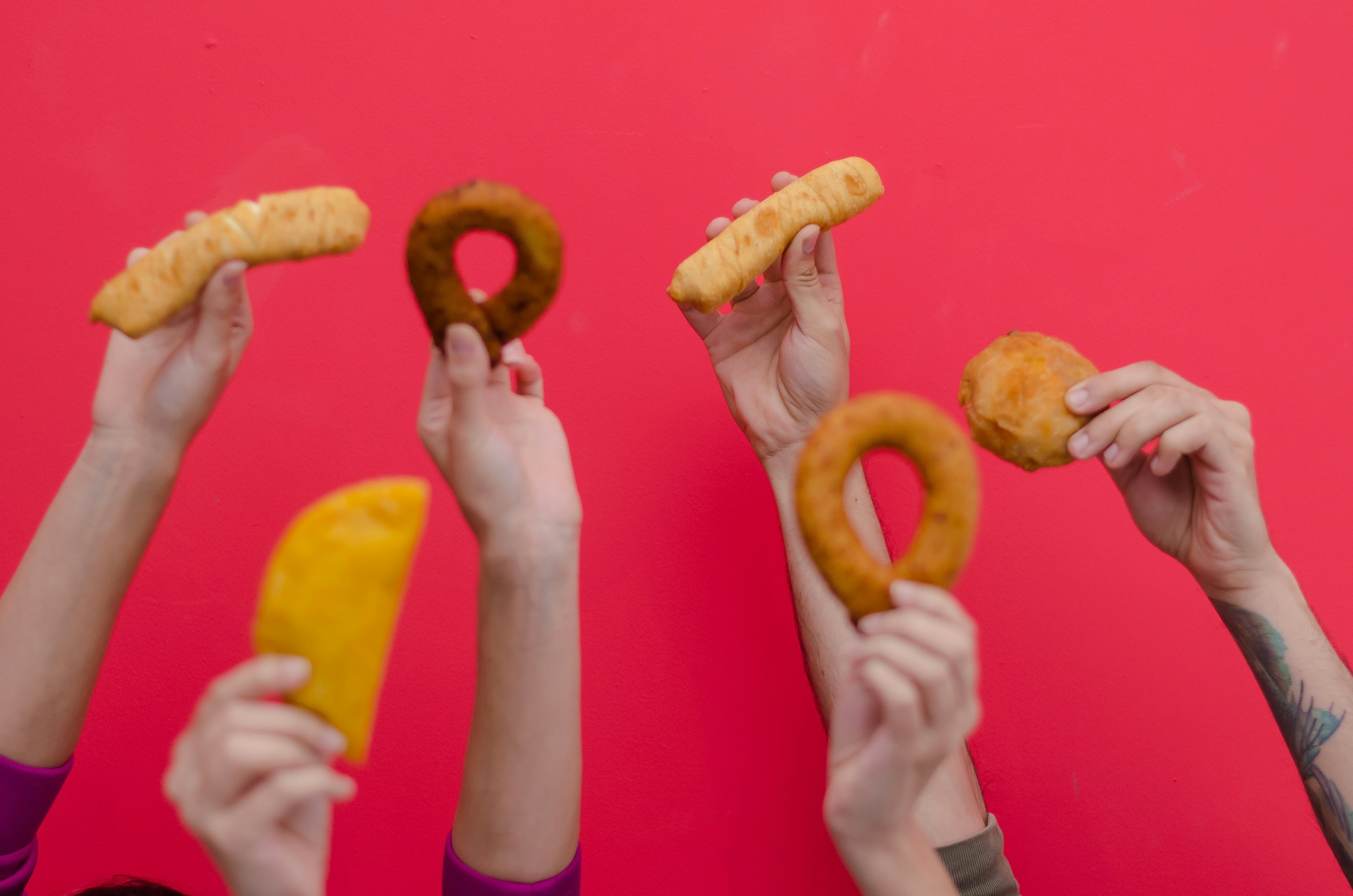 person holding two brown doughnuts