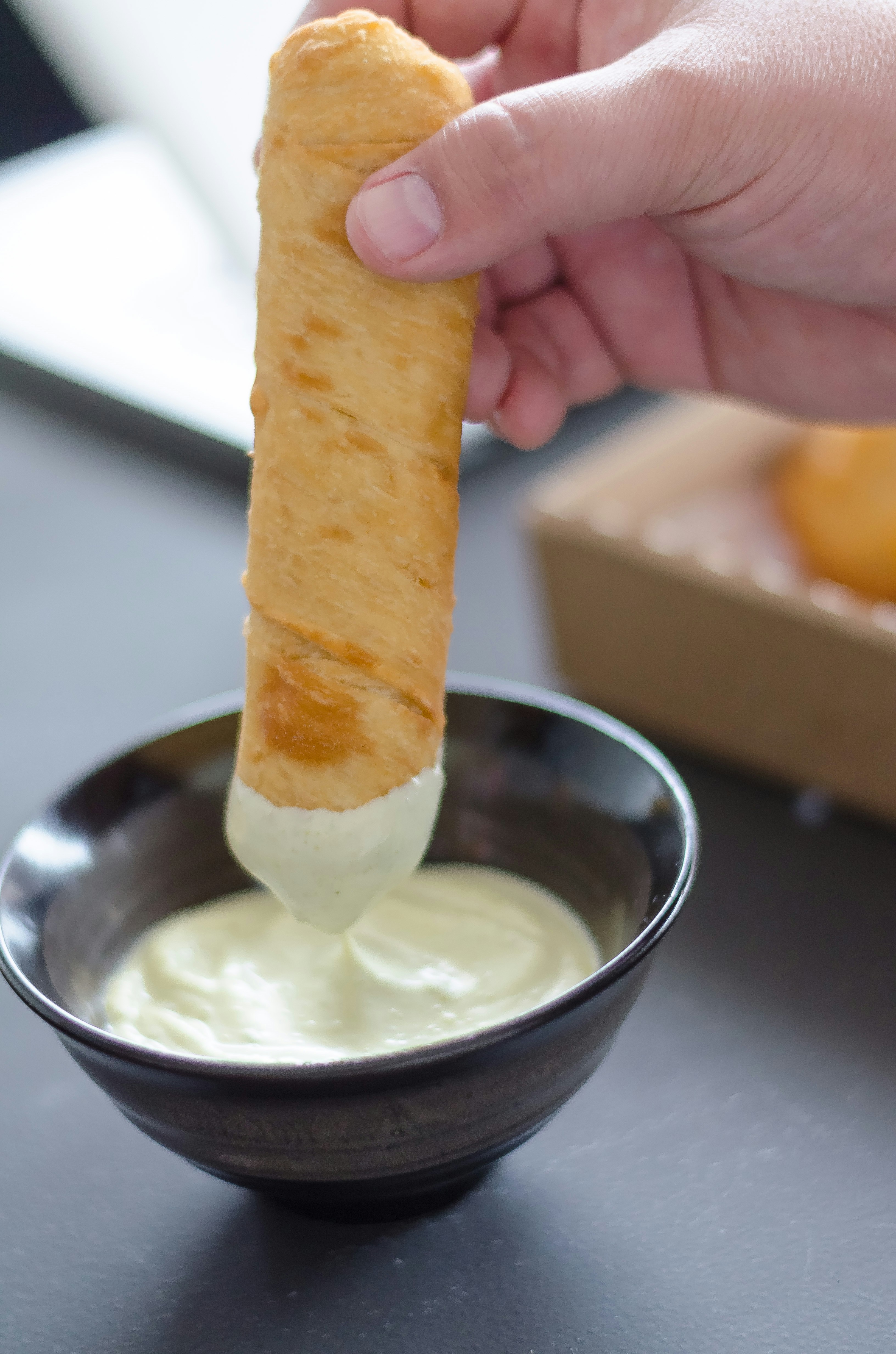 person holding bread with white cream