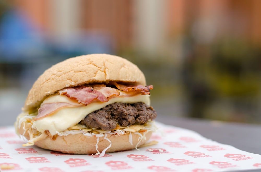 Hamburguesa sobre mantel floral blanco y rojo