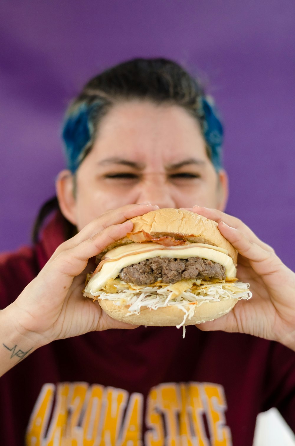 persona sosteniendo hamburguesa con hamburguesa y queso