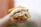 Close-up of a pork sandwich held by a smiling customer with the Galipán food truck visible behind.