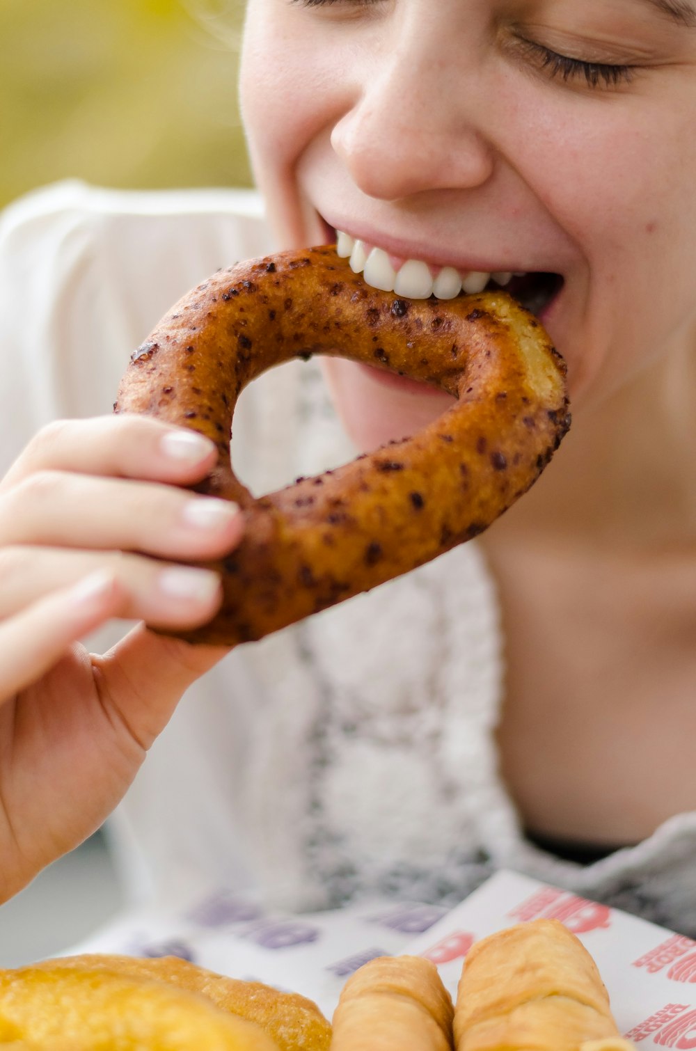 person holding brown doughnut with white cream