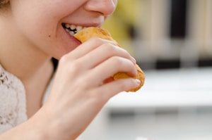woman eating bread during daytime