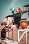 woman in black shirt and black shorts holding orange basketball