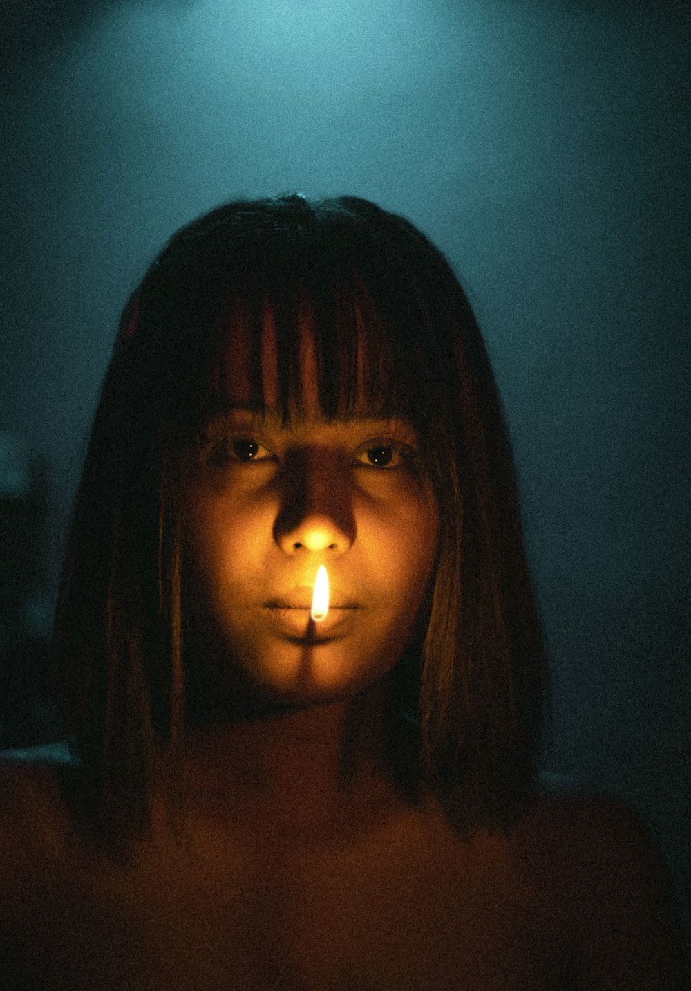 woman with brown hair with lighted candle