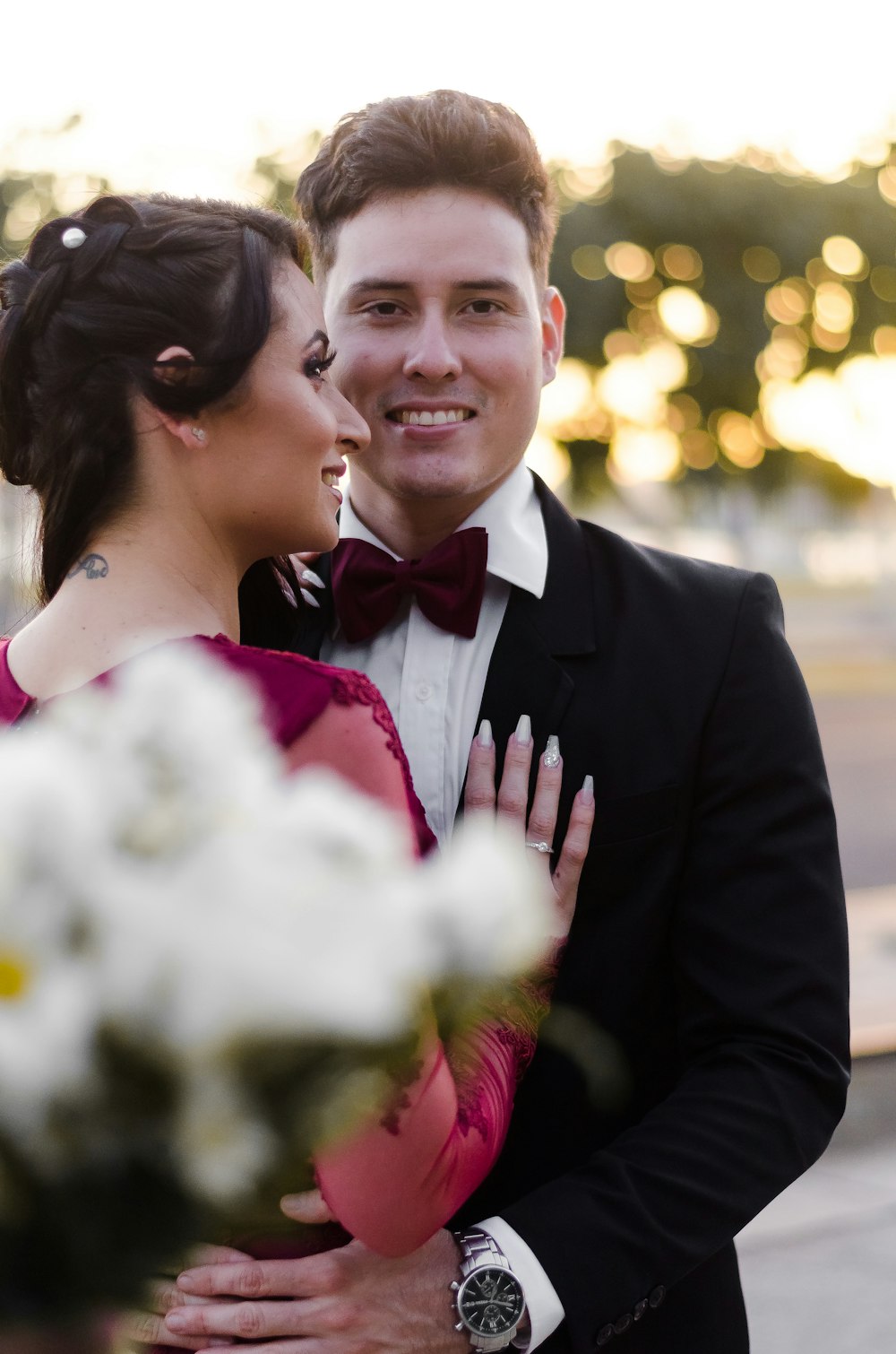 man in black suit jacket kissing woman in white wedding dress