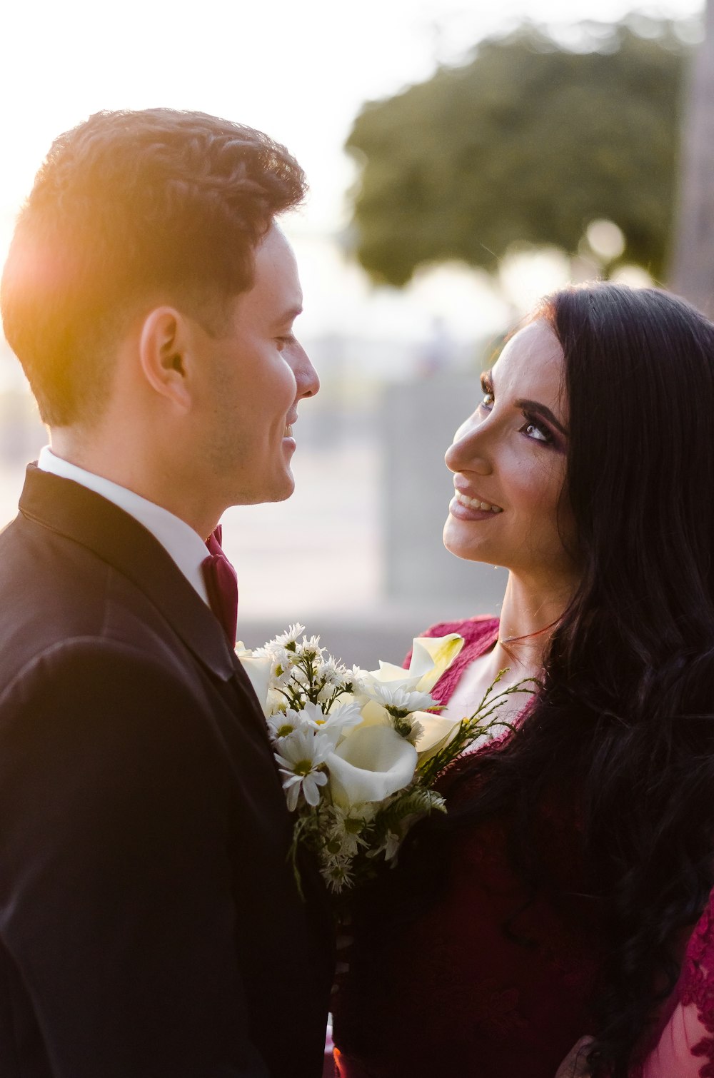 man in black suit jacket kissing woman in white dress