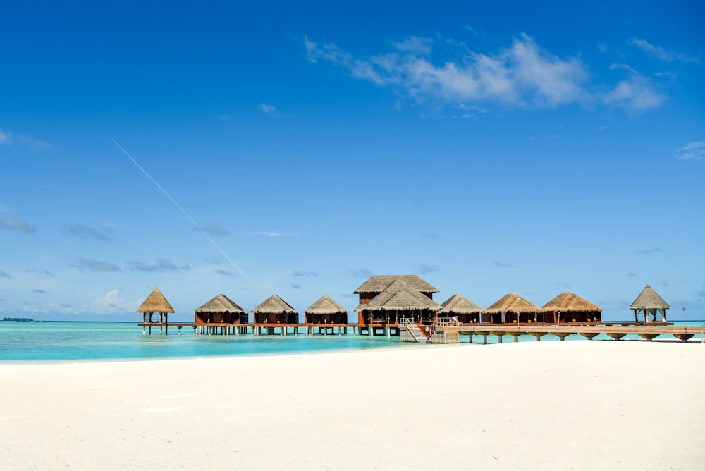 brown wooden beach umbrellas on beach during daytime