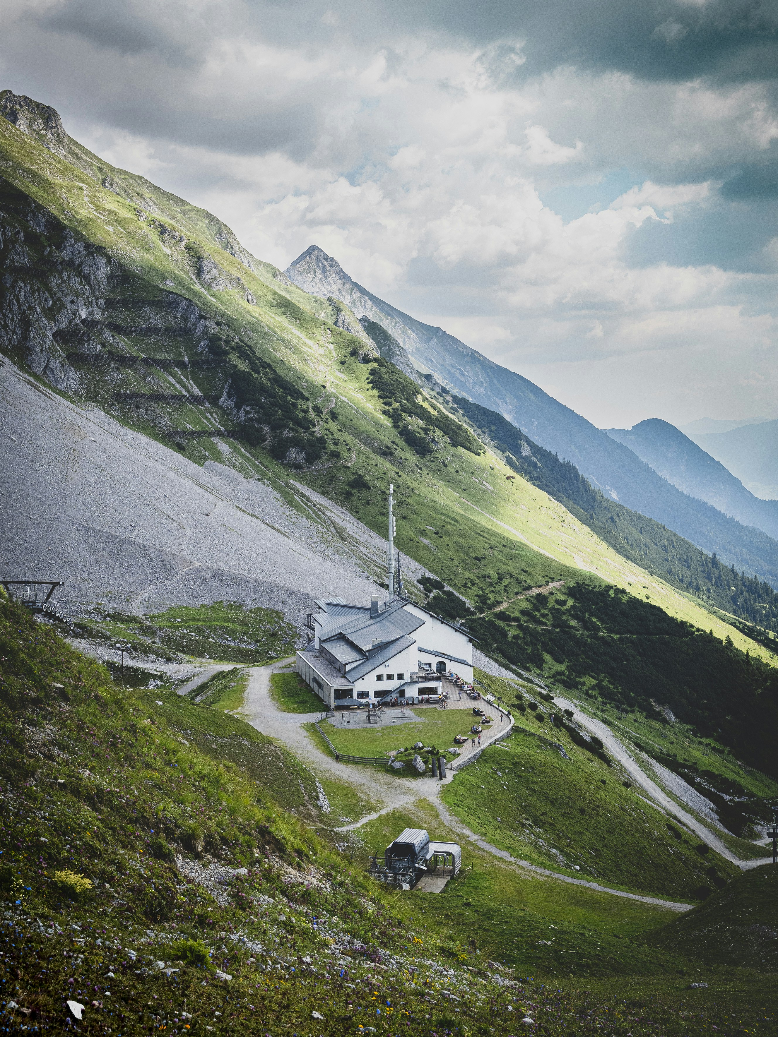 white and black car on green grass field near mountain under white clouds during daytime