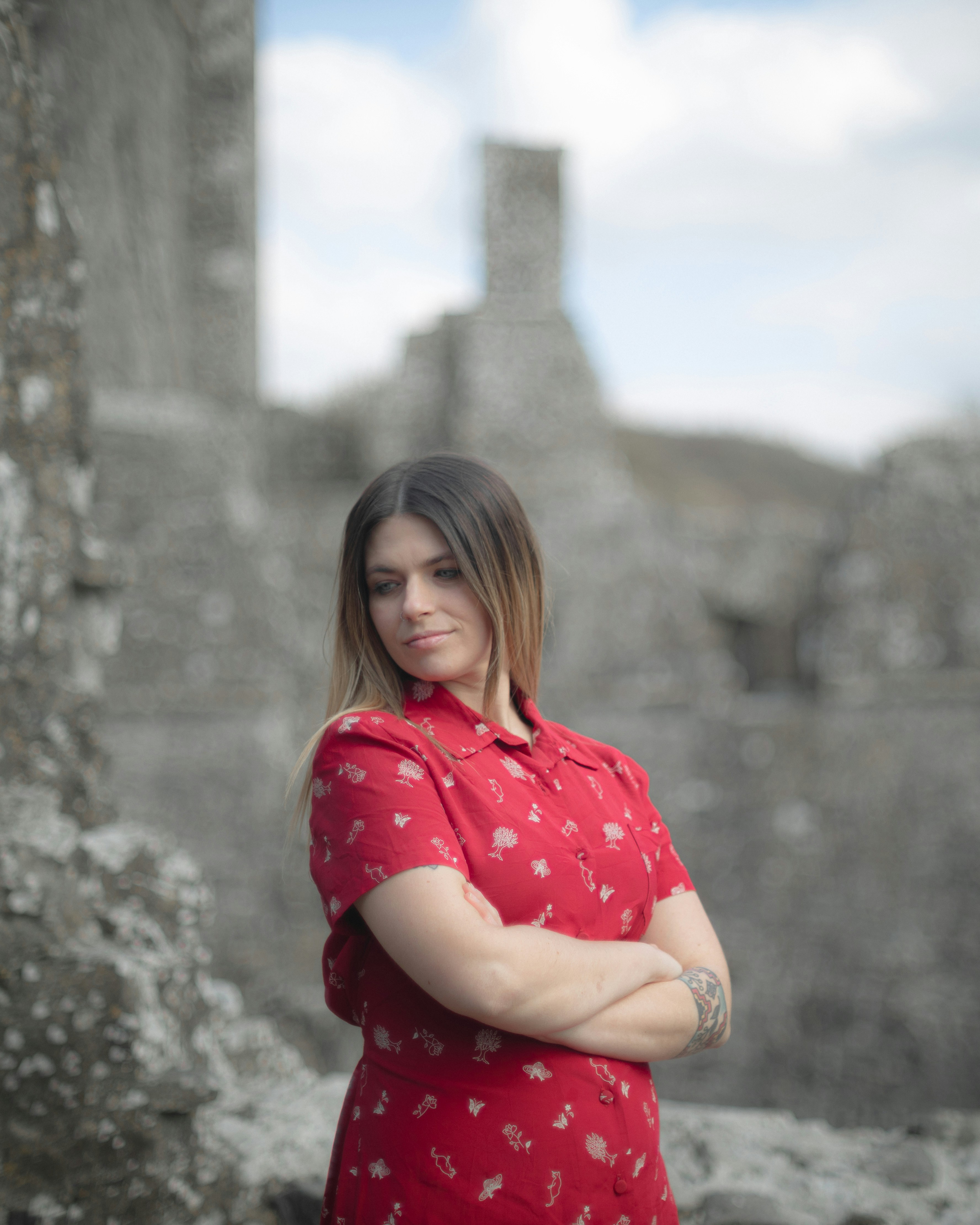 donna in camicia a pois rossa e bianca che si siede sulla roccia