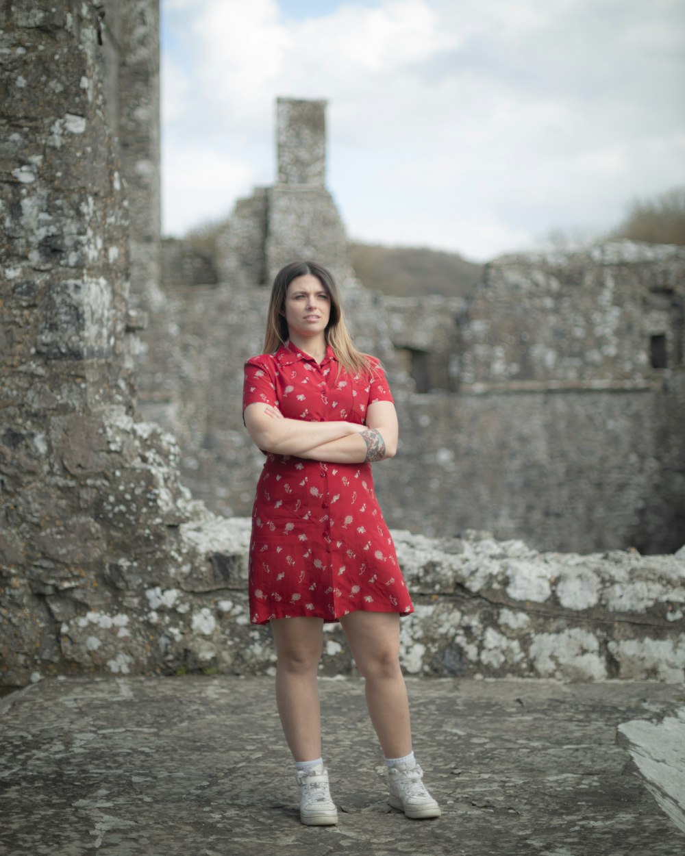 woman in red dress standing on gray sand during daytime