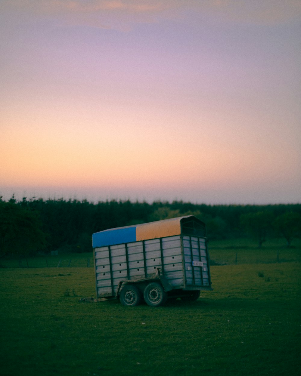 caminhão azul e branco no campo de grama verde durante o dia