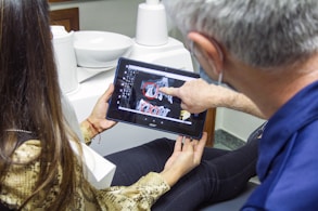 woman in blue denim jeans holding black tablet computer