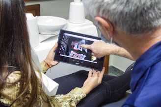 woman in blue denim jeans holding black tablet computer