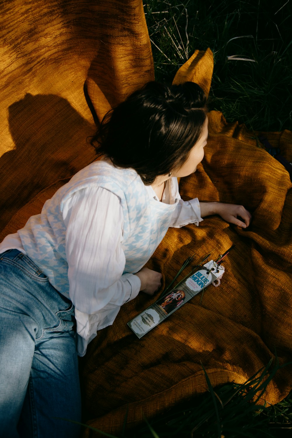 woman in white long sleeve shirt and blue denim jeans sitting on brown sofa