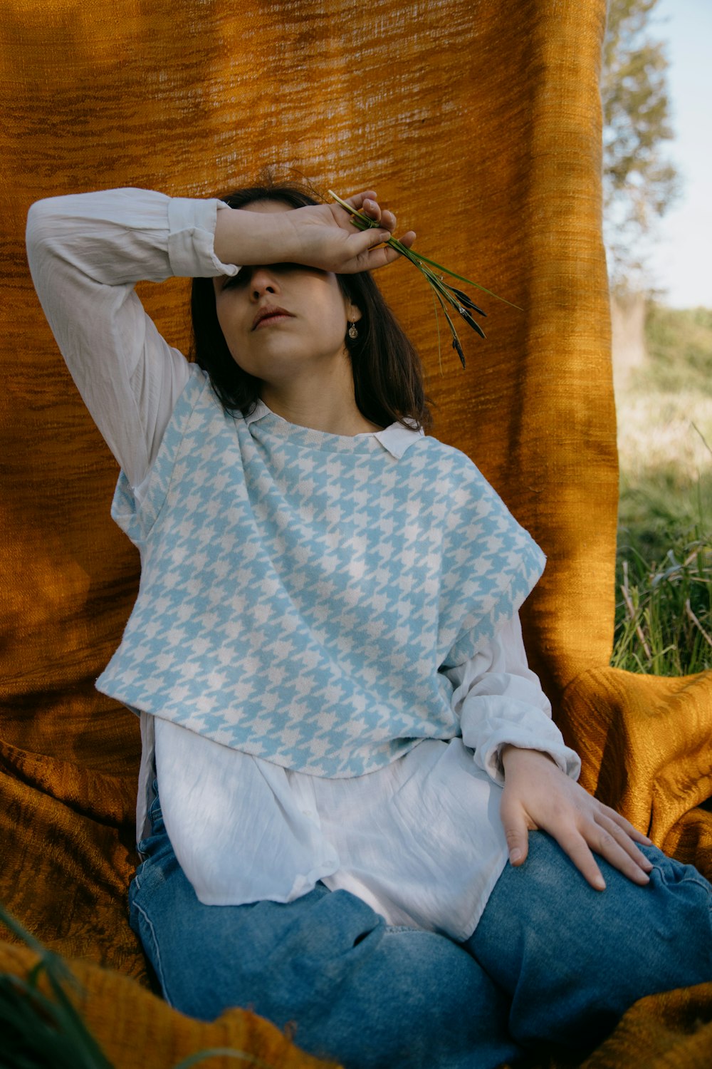 woman in white long sleeve shirt and blue denim jeans sitting on brown wooden bench during