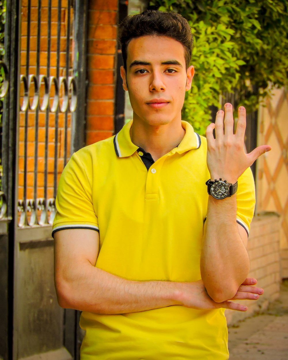 man in yellow polo shirt wearing black and silver round analog watch