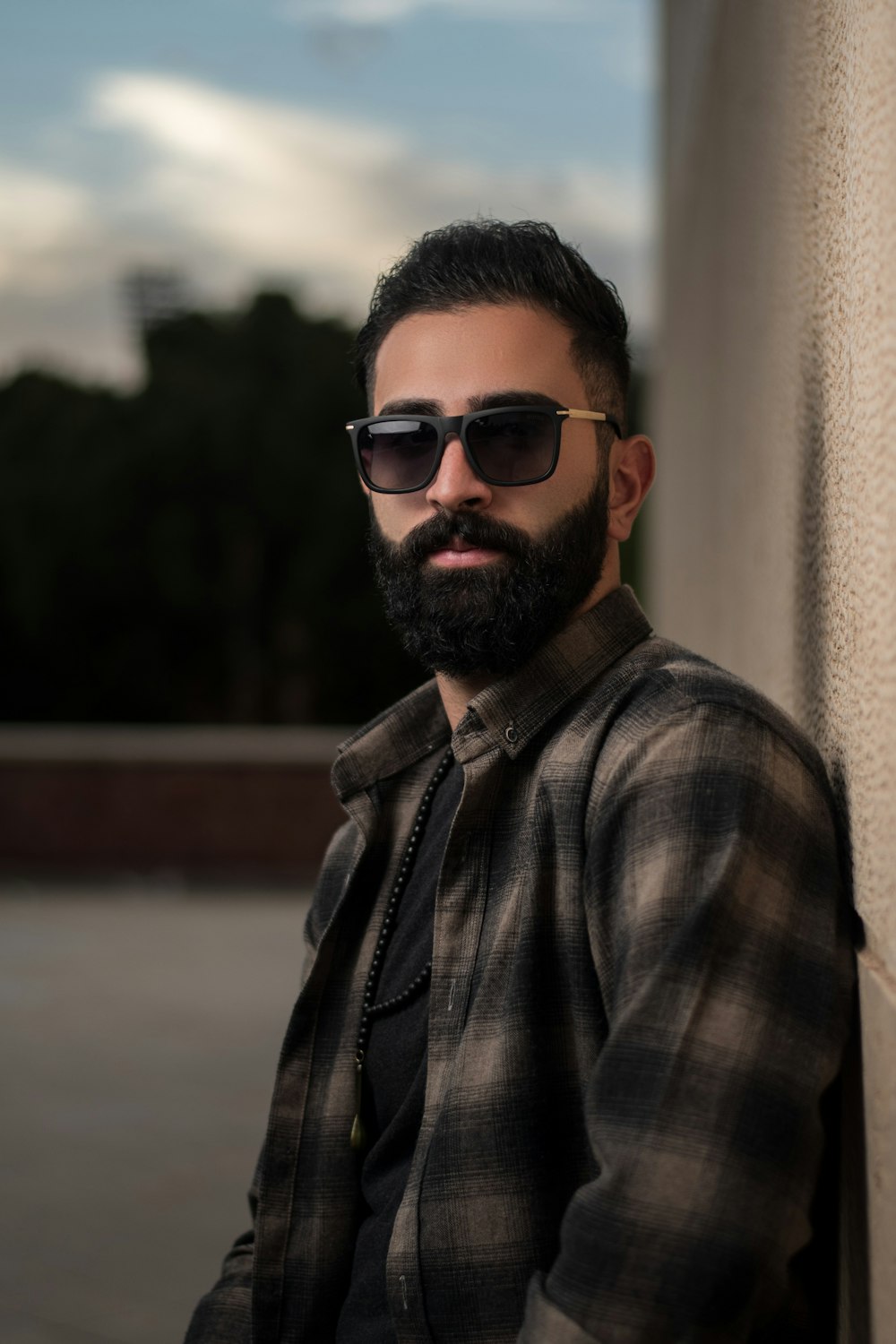 man in black sunglasses and gray and black plaid button up shirt