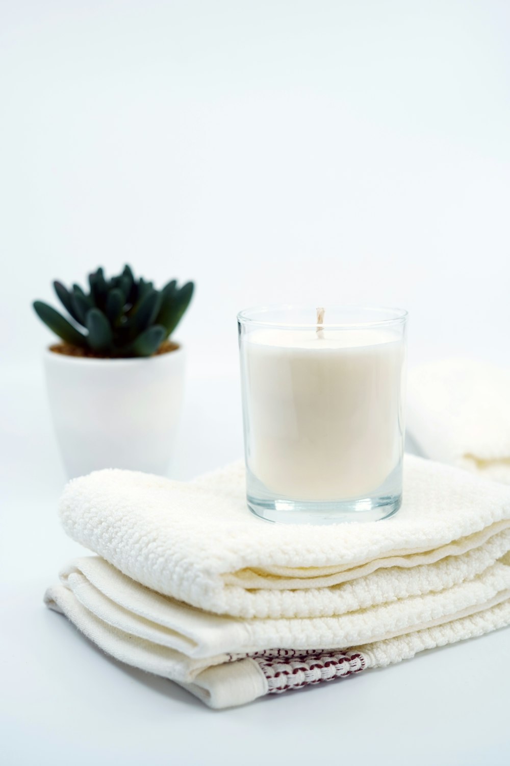 white pillar candle on clear glass candle holder