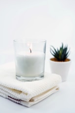 white candle in clear glass candle holder