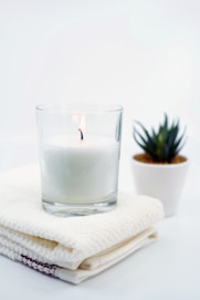 white candle in clear glass candle holder