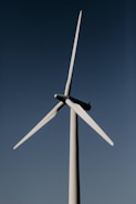 white wind turbine under blue sky during daytime