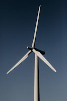 white wind turbine under blue sky during daytime