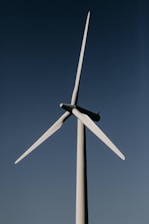 white wind turbine under blue sky during daytime