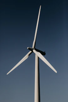 white wind turbine under blue sky during daytime