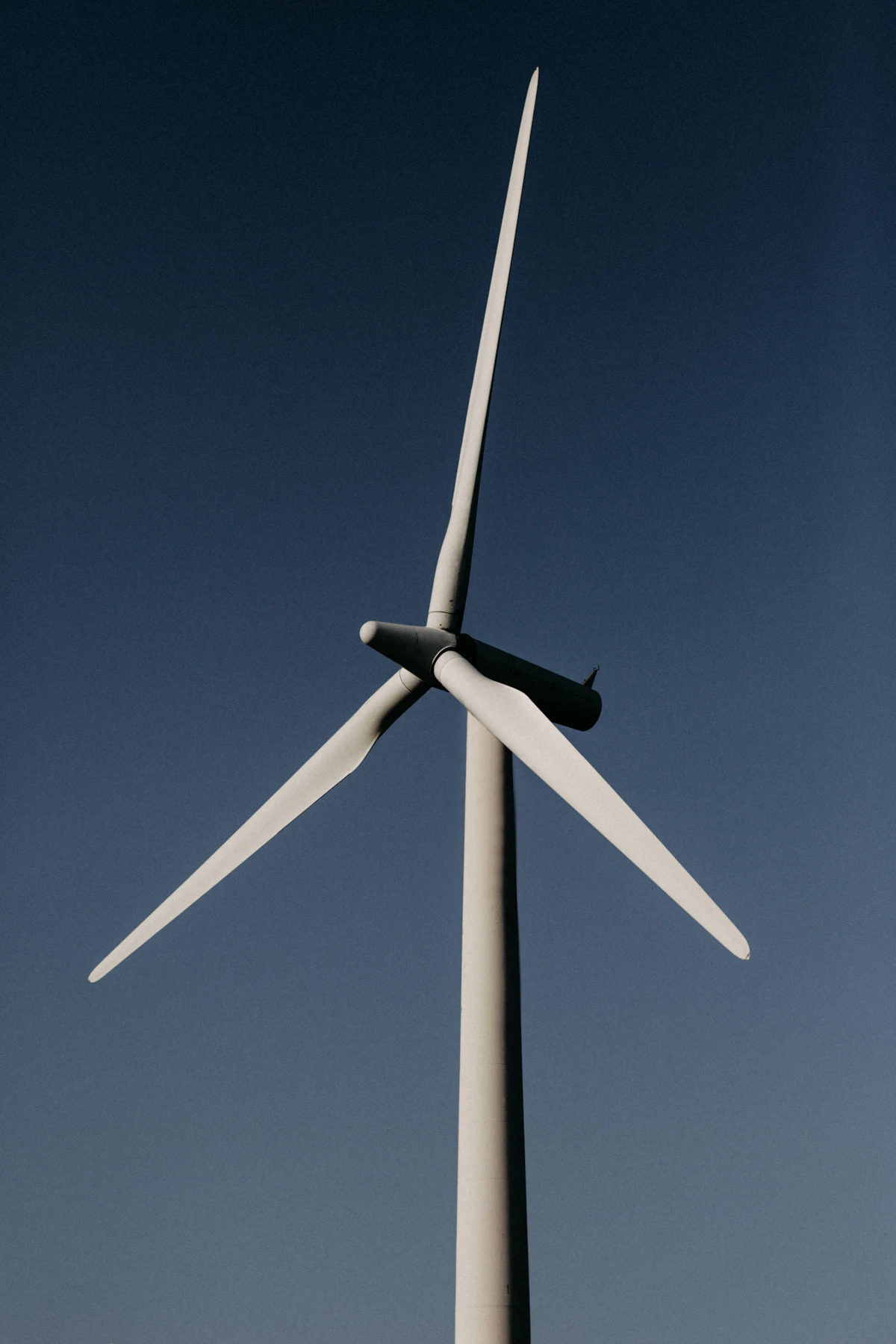 White wind turbine under a blue sky