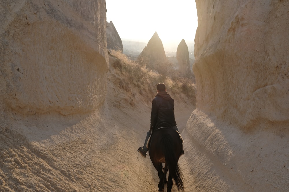 man in black jacket walking on brown dirt road during daytime