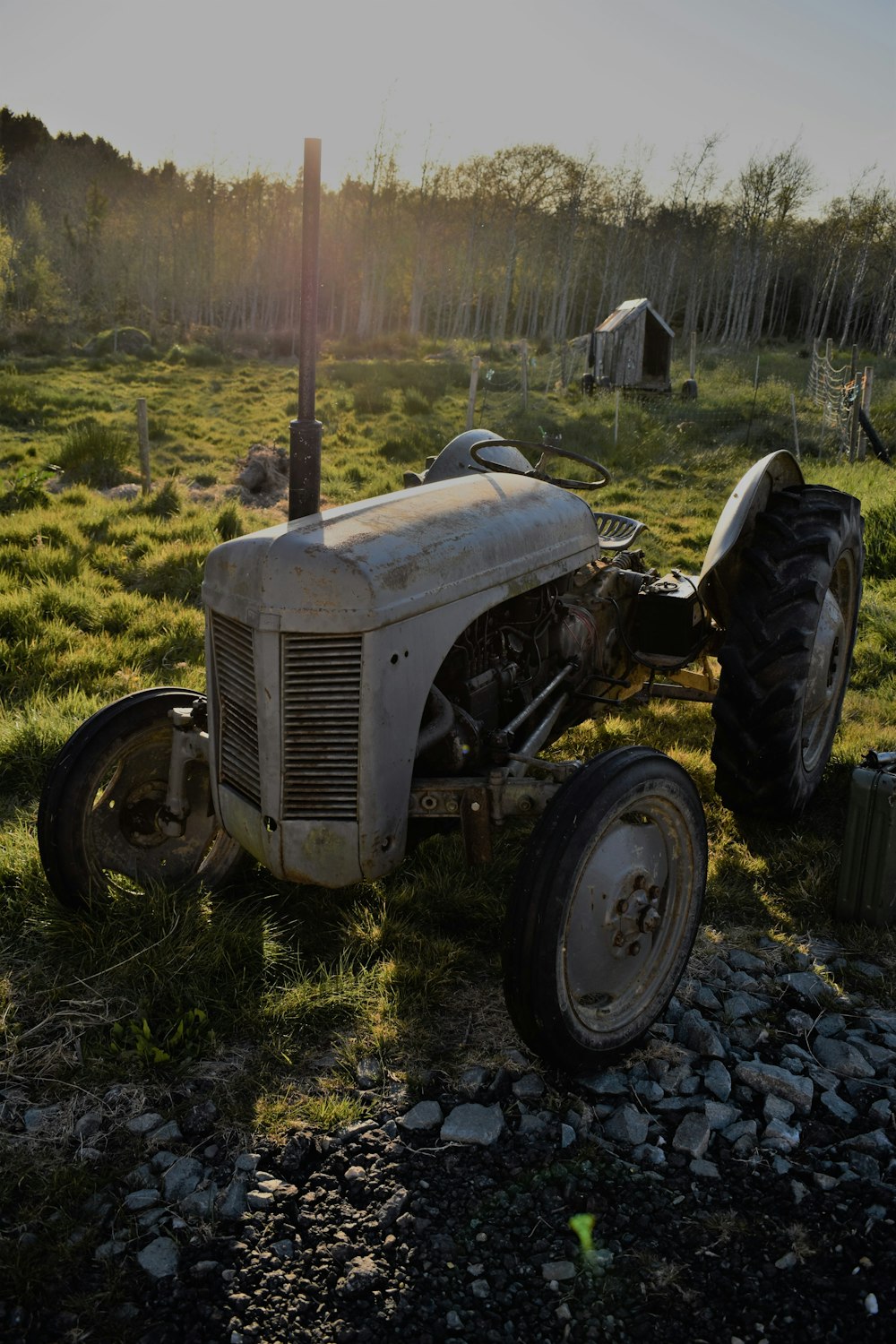 Foto en escala de grises del tractor en el campo de hierba verde