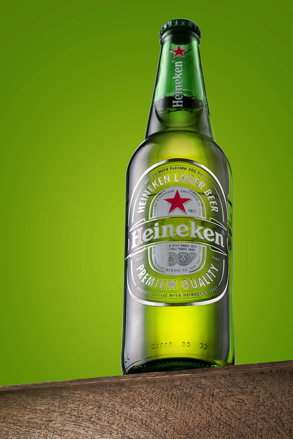 Botella de cerveza Heineken sobre superficie verde