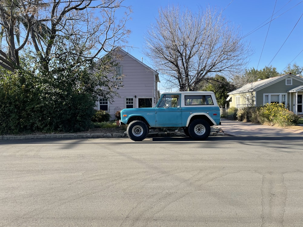 blue and white single cab truck parked near bare trees during daytime