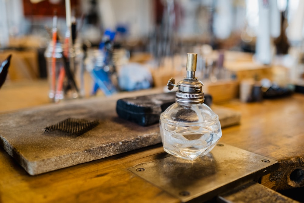 clear glass perfume bottle on brown wooden table