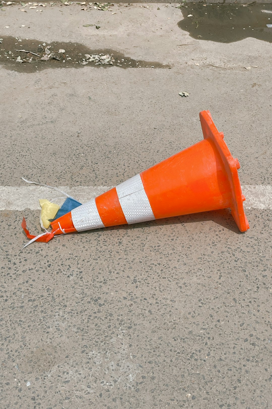 orange and white traffic cone on gray sand