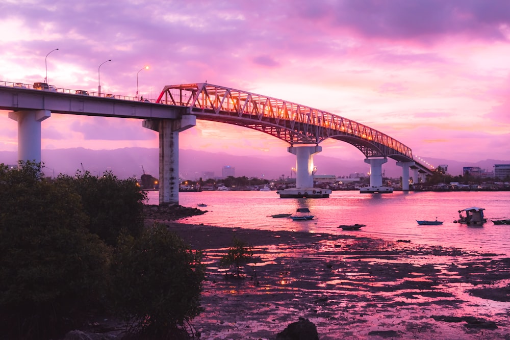 bridge over river under cloudy sky during daytime