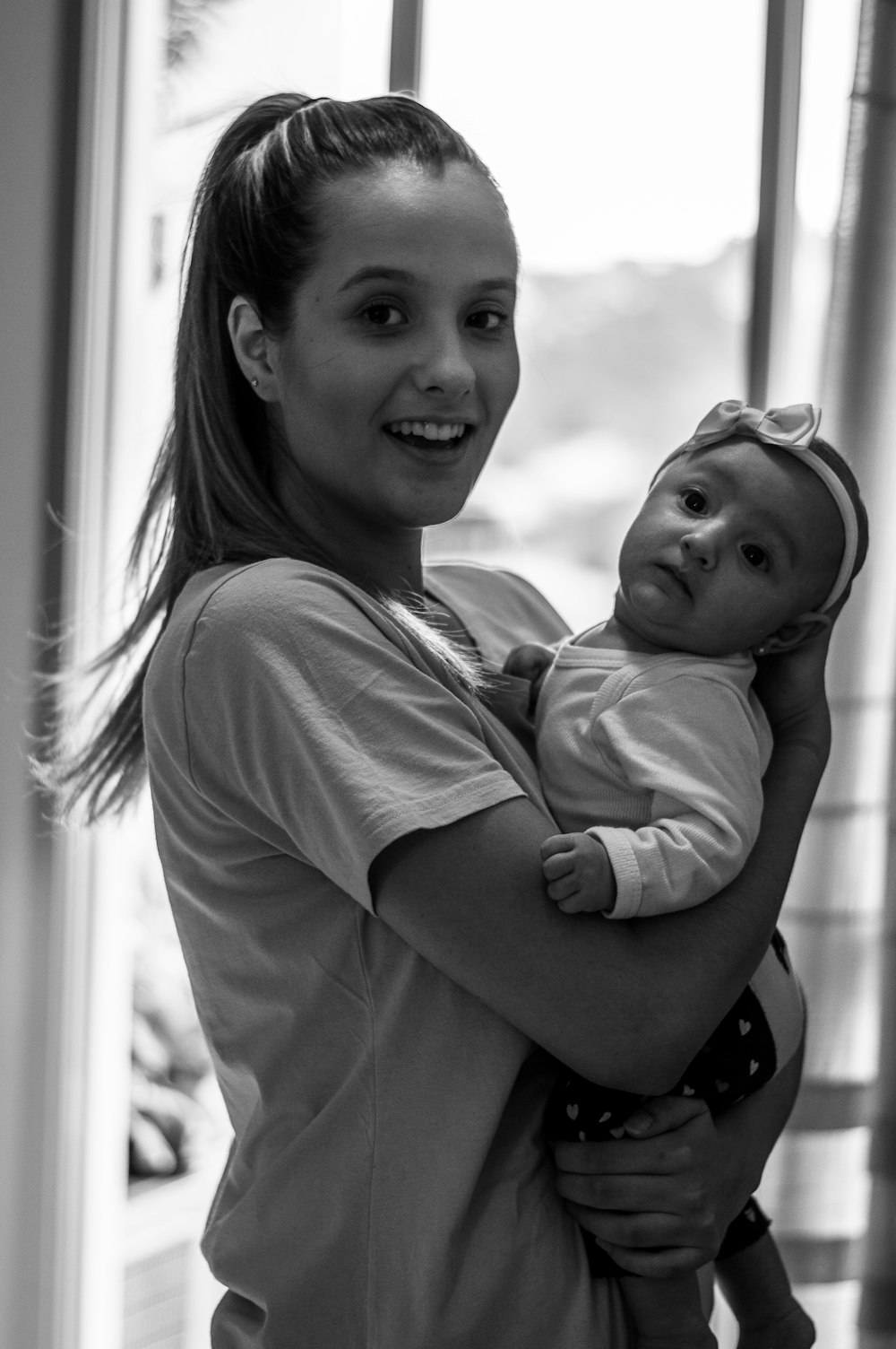 grayscale photo of woman carrying baby