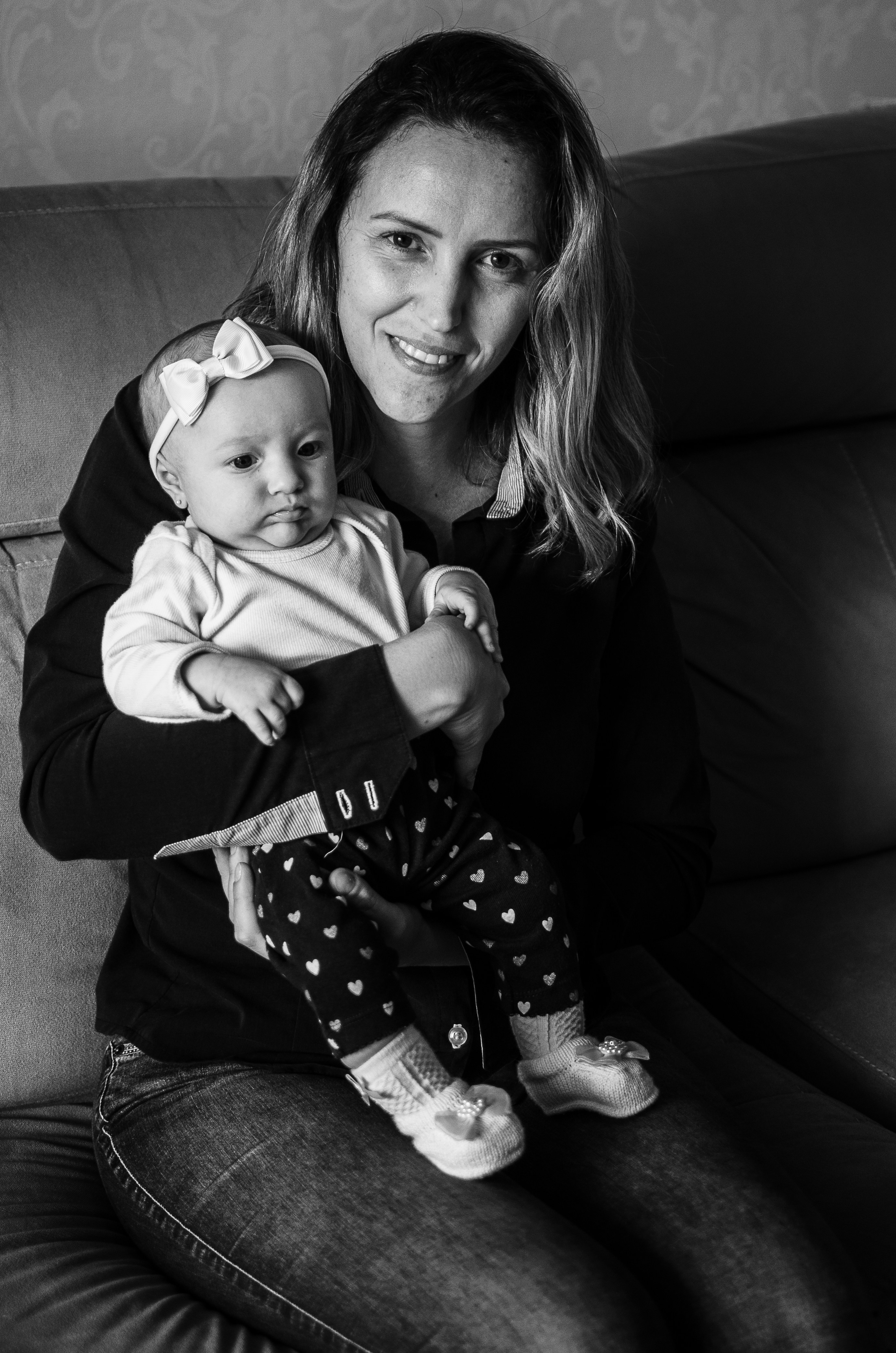 woman in sweater carrying baby in grayscale photography